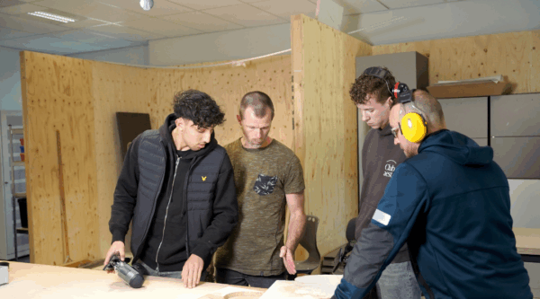 Studenten luisteren naar instructies docent bij de opleiding houttechniek