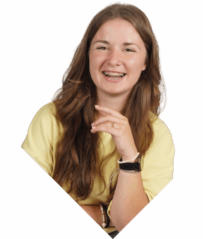 Een student die lachend in de camera kijkt