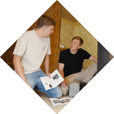 Studenten overleggen met elkaar terwijl ze een tekening vast hebben