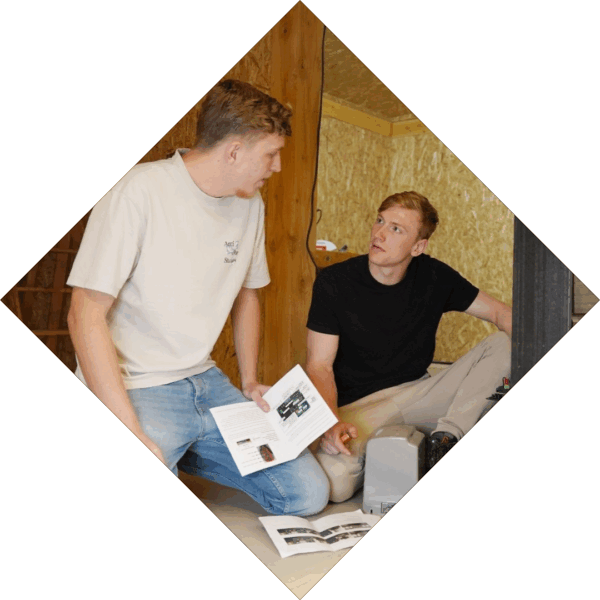 Studenten overleggen met elkaar terwijl ze een tekening vast hebben