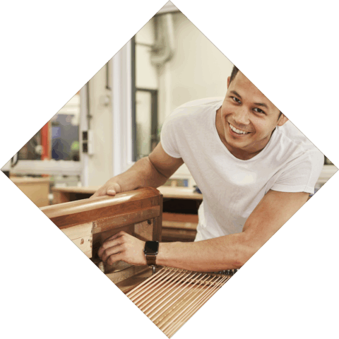 Student pianotechniek lacht naar camera terwijl hij aan piano werkt