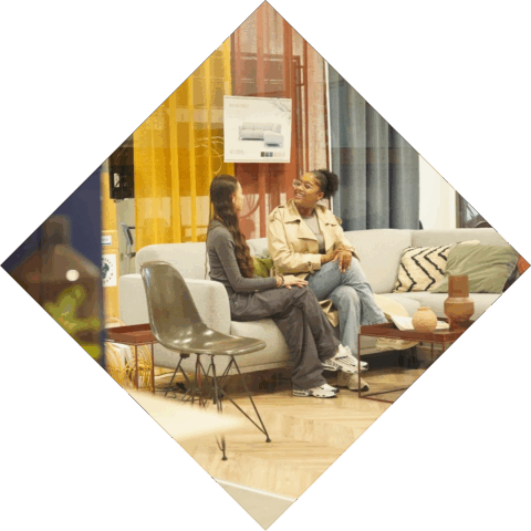 2 studenten zitten op een bank in de woonwinkel van het HMC