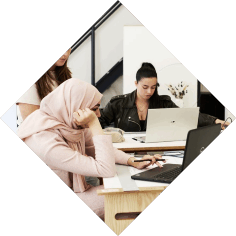 3 studenten zijn met elkaar aan het werken achter een laptop